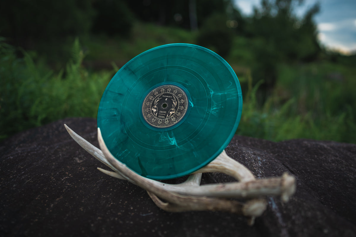 Blackbraid II by Blackbraid, Moss edition vinyl disc: emerald green with bone marbling, on a deer antler